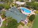 Aerial view of community pool and clubhouse with outdoor kitchen, dining, and lake views at 3060 Pirates Retreat Ct # 309, Kissimmee, FL 34747