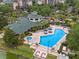 Aerial view of a community pool and clubhouse with plenty of seating and a hot tub at 3060 Pirates Retreat Ct # 309, Kissimmee, FL 34747
