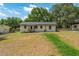 View of the backyard with a house, grass, shed, and trees at 308 Forest St, Fruitland Park, FL 34731