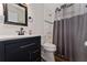 This bathroom has an updated vanity, toilet, mirror, and shower with dark grey curtain at 308 Forest St, Fruitland Park, FL 34731
