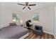 Bright bedroom with wood-look flooring, fan, desk with computer, and accent chair at 308 Forest St, Fruitland Park, FL 34731