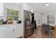 A kitchen features stainless steel appliances, white cabinets, and an adjacent dining area at 308 Forest St, Fruitland Park, FL 34731