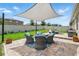 Inviting backyard patio with elegant shade cover, wicker seating, and manicured lawn for outdoor enjoyment at 3443 Florigold Grove St, Clermont, FL 34711