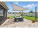 The brick patio in the backyard features a shade cover and is furnished with comfortable seating and lawn space at 3443 Florigold Grove St, Clermont, FL 34711