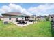 This is a spacious backyard featuring a brick patio, lounge chairs, an umbrella, and a lush, green lawn at 3443 Florigold Grove St, Clermont, FL 34711