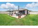 This backyard with a brick patio includes lounge chairs, a shade cover, and a well-maintained lawn at 3443 Florigold Grove St, Clermont, FL 34711