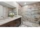 The bathroom boasts a double sink vanity, a glass-enclosed shower, and elegant wood-look tile at 3443 Florigold Grove St, Clermont, FL 34711