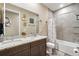 Bathroom showcasing double sinks with granite countertop and tiled shower and bathtub at 3443 Florigold Grove St, Clermont, FL 34711