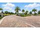 Wide view of the Waterbrooke community entrance, complemented by palms, and brick paved roads at 3443 Florigold Grove St, Clermont, FL 34711