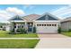 Charming single-Gathering home featuring a brick driveway, a two-car garage and stylish blue accents at 3443 Florigold Grove St, Clermont, FL 34711
