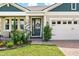 Inviting entryway featuring a decorative wreath, colorful flowers, and stone columns at 3443 Florigold Grove St, Clermont, FL 34711
