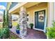 Cozy front porch with stone pillars, a decorated front door, and lush landscaping at 3443 Florigold Grove St, Clermont, FL 34711