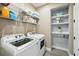 Well-organized laundry room with modern appliances and shelving for storage at 3443 Florigold Grove St, Clermont, FL 34711