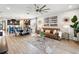 Open-concept living room features a modern chandelier, stylish decor, and a seamless transition to the kitchen at 3443 Florigold Grove St, Clermont, FL 34711