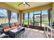 Comfortable screened-in patio with gray wicker seating, brick floor, fan, and an outdoor view at 3443 Florigold Grove St, Clermont, FL 34711