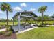 Outdoor picnic area with covered seating surrounded by green spaces and mature palms at 3443 Florigold Grove St, Clermont, FL 34711