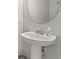 Modern bathroom sink features a sleek white pedestal sink, a round mirror, and stylish fixtures at 352 Smugglers Way, Apopka, FL 32712