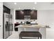 Kitchen featuring stainless steel appliances, granite countertops, and dark wood cabinets at 352 Smugglers Way, Apopka, FL 32712