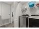 This laundry room includes a modern washer and dryer and overhead storage at 352 Smugglers Way, Apopka, FL 32712