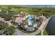 Aerial view of a community pool, a clubhouse, and lush landscaping near a lake at 3575 Landing Net Dr, Kissimmee, FL 34746