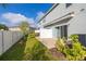 View of the backyard featuring an exterior door, privacy fence and small trees at 3575 Landing Net Dr, Kissimmee, FL 34746