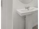 Bathroom features a modern pedestal sink and a round mirror at 3575 Landing Net Dr, Kissimmee, FL 34746