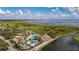 Aerial view of the community pool and splash pad with lush landscaping overlooking the lake at 3575 Landing Net Dr, Kissimmee, FL 34746