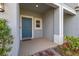 Inviting front porch with stylish blue door, white trim, and decorative landscaping at 3575 Landing Net Dr, Kissimmee, FL 34746