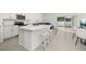Stylish kitchen with a large quartz island, stainless steel appliances, and adjacent dining and living areas at 3575 Landing Net Dr, Kissimmee, FL 34746