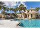 Relaxing community pool surrounded by palm trees, comfortable lounge chairs, and a vibrant blue sky at 3575 Landing Net Dr, Kissimmee, FL 34746