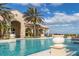 Inviting pool area with decorative planters and seating, set against a beautiful building and clear blue sky at 3575 Landing Net Dr, Kissimmee, FL 34746