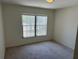 Neutral bedroom features wall-to-wall carpeting and a window with bright natural light at 369 St Georges Cir, Eagle Lake, FL 33839