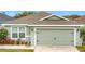 Charming home featuring a well-maintained lawn, a two-car garage, and light green paint at 369 St Georges Cir, Eagle Lake, FL 33839