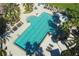 Aerial view of a stunning community pool with unique shape, surrounded by palm trees and luxurious lounge areas at 3881 Shoreside Dr, Kissimmee, FL 34746