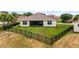 Home featuring a spacious backyard with a privacy fence, a well-maintained lawn, and a screened patio at 3881 Shoreside Dr, Kissimmee, FL 34746