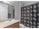 Bathroom with single sink, light colored countertops, dark wood vanity and UCF Knights shower curtain at 3881 Shoreside Dr, Kissimmee, FL 34746