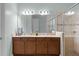Well lit bathroom with double vanity, modern fixtures, large mirror, and glass enclosed shower at 3881 Shoreside Dr, Kissimmee, FL 34746