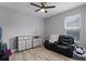 Neutral tone bedroom with luxury plank floors, ceiling fan, leather sofa, and window for natural light at 3881 Shoreside Dr, Kissimmee, FL 34746