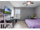Bedroom with wood floors, light gray walls, black dresser, flat screen TV, and lots of light at 3881 Shoreside Dr, Kissimmee, FL 34746