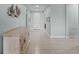 Well-lit hallway showcasing tile flooring, neutral paint, and stylish modern décor with an entry to another room at 3881 Shoreside Dr, Kissimmee, FL 34746