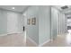 Bright hallway featuring neutral paint, tile floors, and modern decor, offering access to various rooms in the home at 3881 Shoreside Dr, Kissimmee, FL 34746