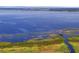 Panoramic aerial shot of a tranquil lake, showcasing a wooden walkway amidst lush marshland and blue water at 3881 Shoreside Dr, Kissimmee, FL 34746