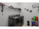 Laundry room with full size black front load washer and dryer and wire rack for storage at 3881 Shoreside Dr, Kissimmee, FL 34746