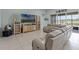 Open-concept living area with tile floors, modern furniture, large windows and sliding glass doors with lovely exterior views at 3881 Shoreside Dr, Kissimmee, FL 34746
