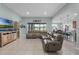 Bright and open living space with tile flooring, comfortable seating, and serene views of the lake beyond the sliding glass doors at 3881 Shoreside Dr, Kissimmee, FL 34746