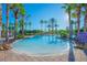 Beautiful community pool featuring palm trees, clear blue water, and plenty of lounge chairs at 3881 Shoreside Dr, Kissimmee, FL 34746