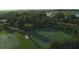 Aerial view of a tennis court with well-maintained green surface, set amidst lush landscaping in a residential community at 3881 Shoreside Dr, Kissimmee, FL 34746