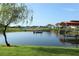 Picturesque waterfront view with a boat and community boat dock house, complemented by lush greenery and scenic surroundings at 3881 Shoreside Dr, Kissimmee, FL 34746