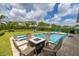 Inviting backyard pool area with patio seating, fire pit and adjacent lawn and play area, perfect for outdoor relaxation and entertainment at 420 Burma St, Kissimmee, FL 34747