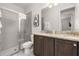 Bathroom with a glass shower, granite countertops, a dual sink vanity and modern fixtures at 420 Burma St, Kissimmee, FL 34747
